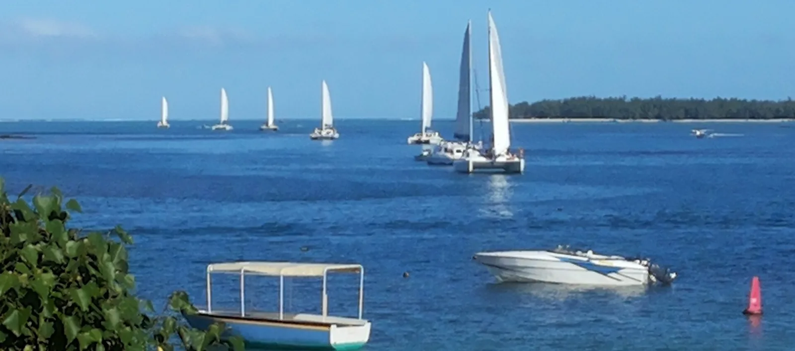 Catamarans à voiles sur le lagon de l'est au large de Trou d'Eau Douce, île aux Cerfs à l'horizon