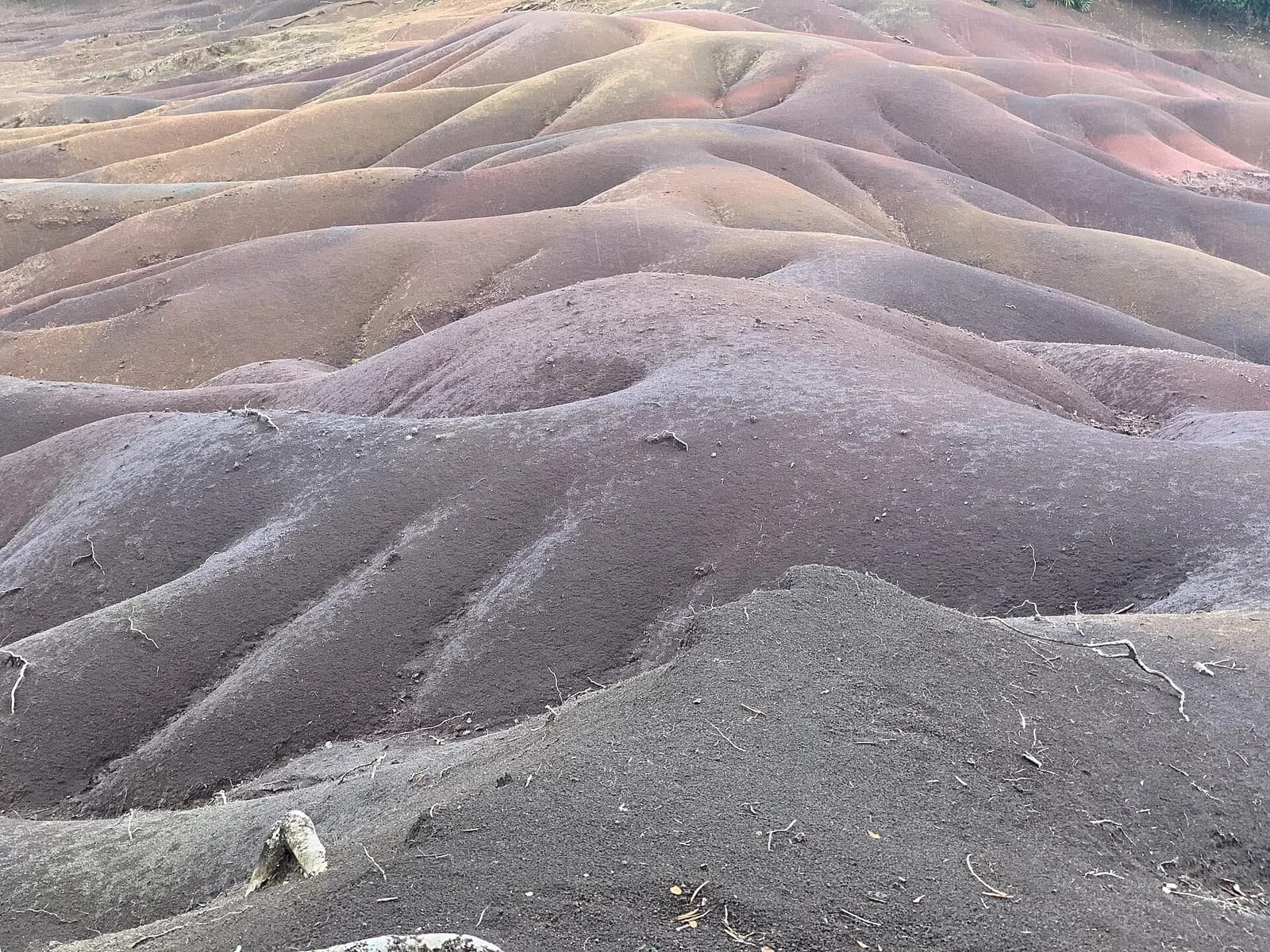 Ondulations de sable coloré gris-violet et brun de la Terre des Sept Couleurs à Chamarel, Maurice