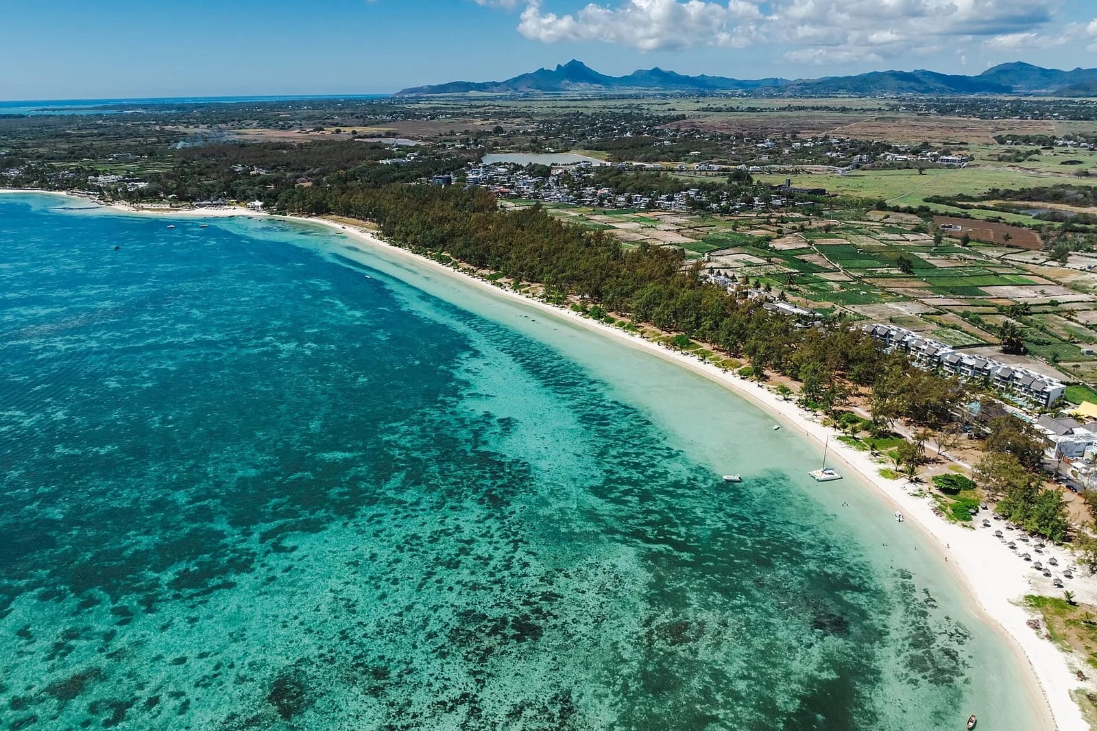 Vue aérienne de la longue plage de Belle Mare, lagon turquoise et filaos, côte est de l'île Maurice
