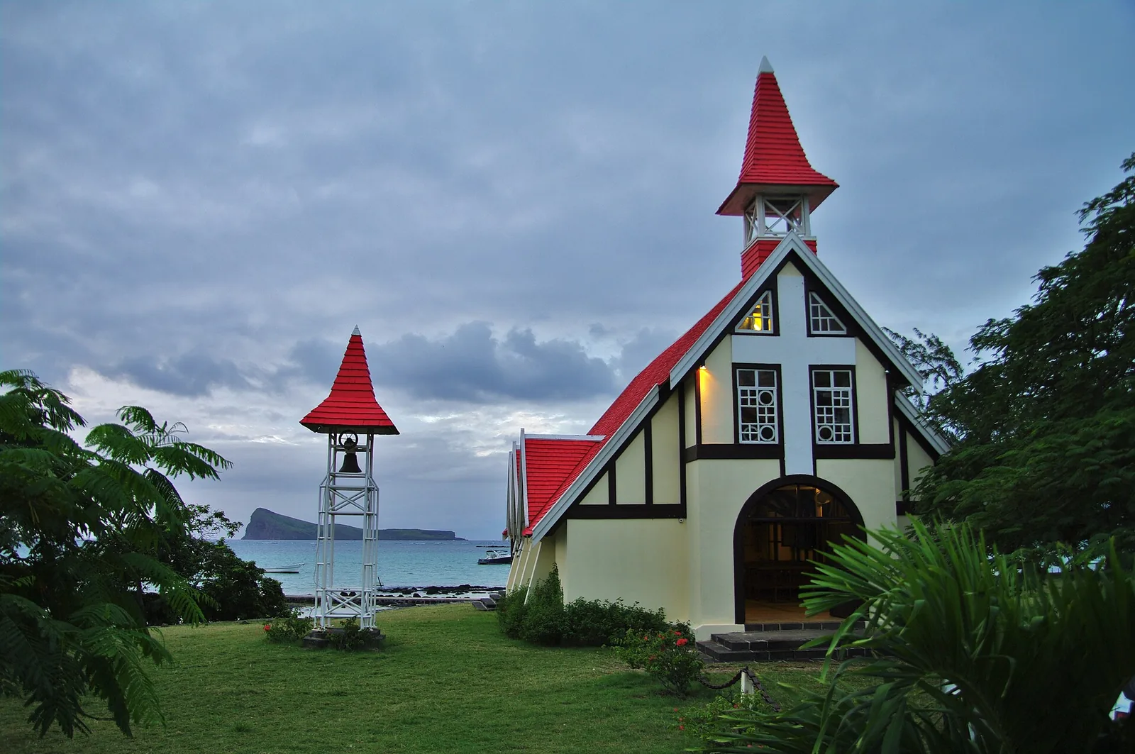 L'église Notre-Dame-Auxiliatrice au toit rouge de Cap Malheureux, avec le Coin de Mire au loin