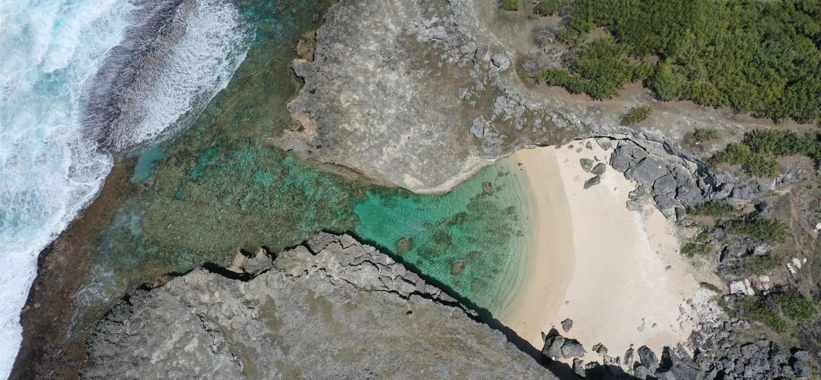 Crique de sable entre falaises sur la côte de Rodrigues, vue aérienne