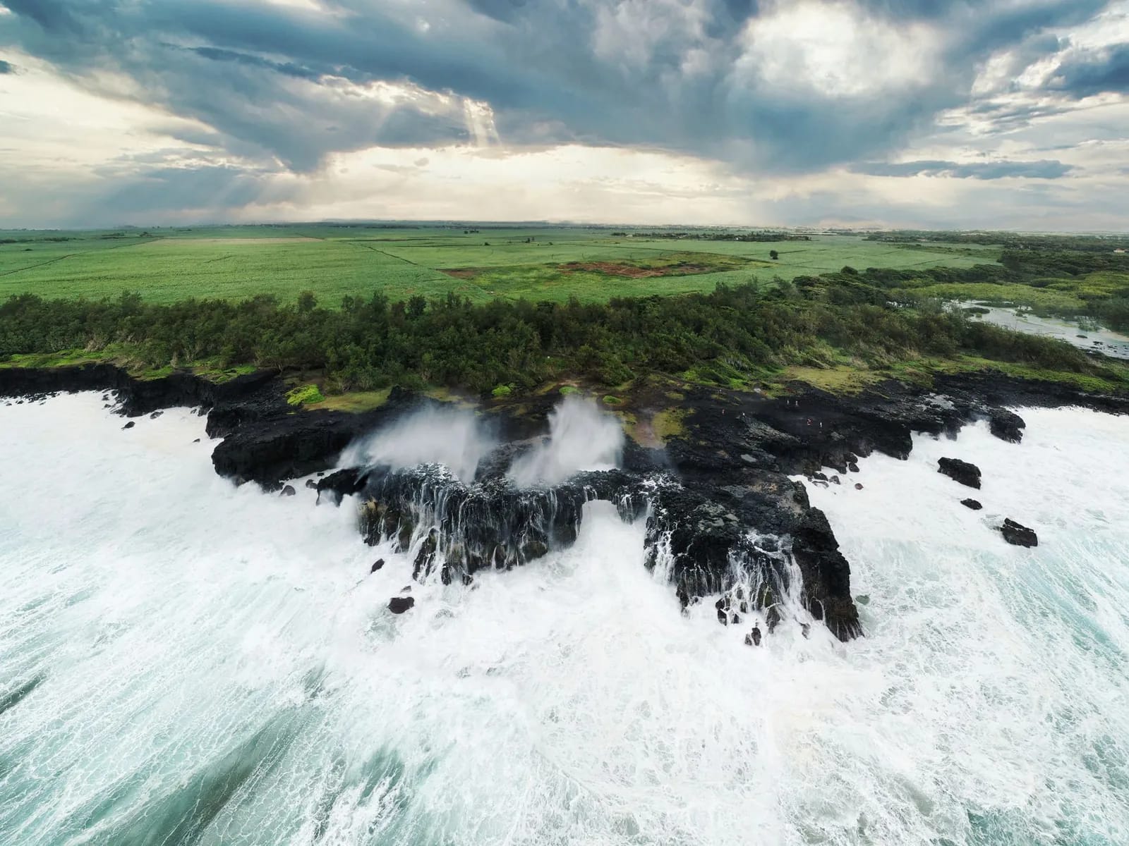 Vagues de l'océan Indien s'écrasant sur des rochers noirs, côte sud de Maurice
