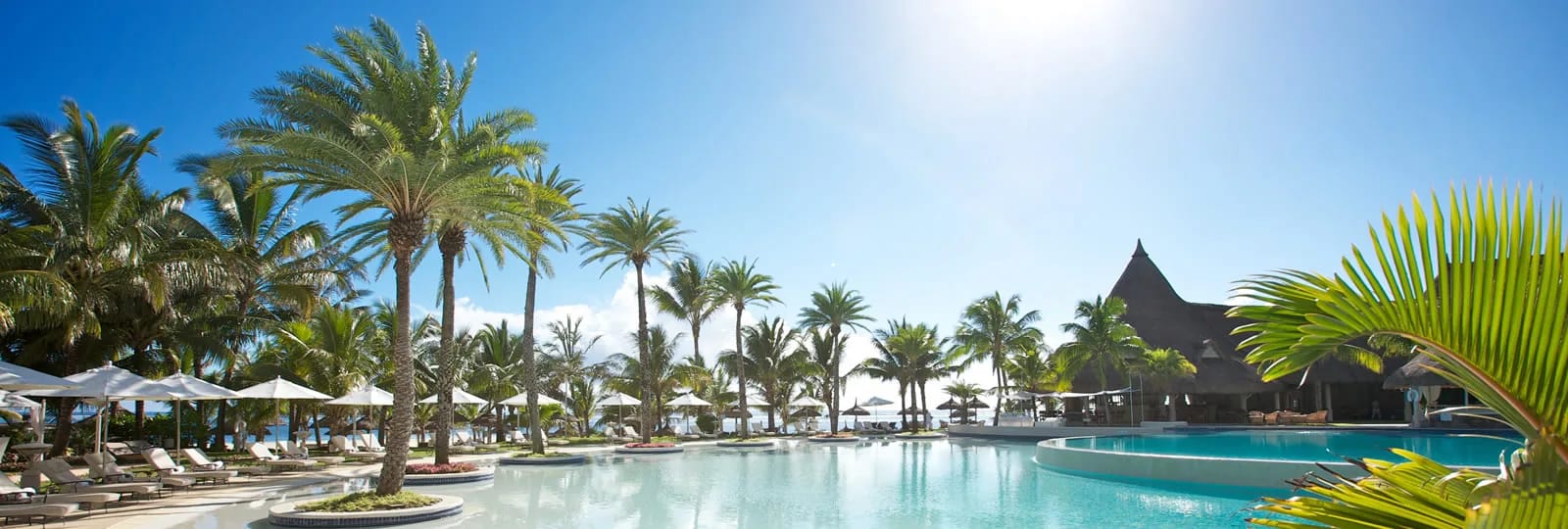 Piscine et palmiers du LUX* Belle Mare, hôtel de bord de plage à Belle Mare