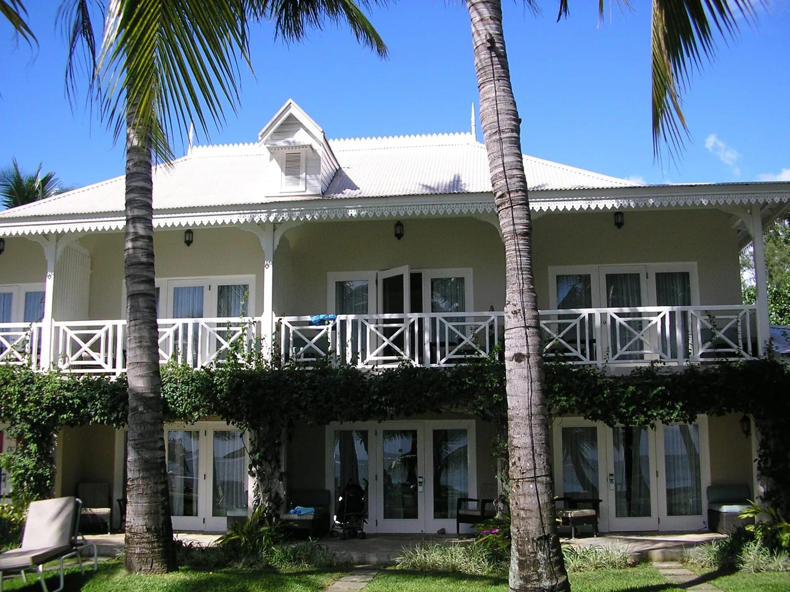 Bâtiment colonial blanc du Sugar Beach Resort entre les palmiers, à Wolmar, île Maurice