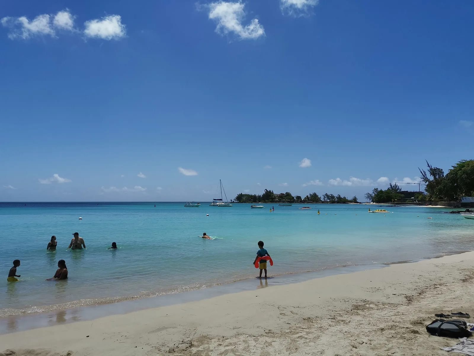 Enfants et baigneurs dans l'eau de la plage de Péreybère, au nord de Maurice